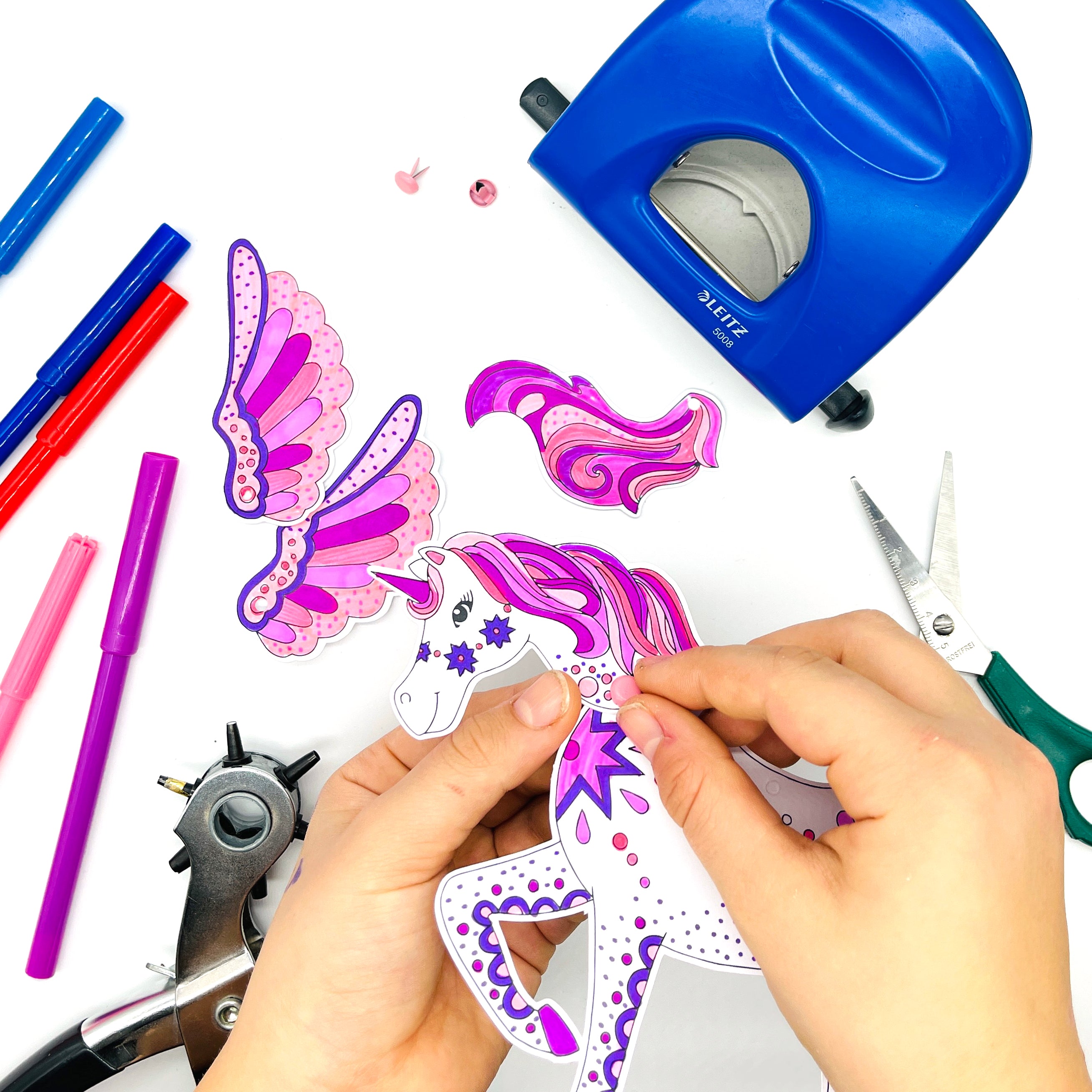 Using split pins to join the head and and tail to the unicorn kids craft