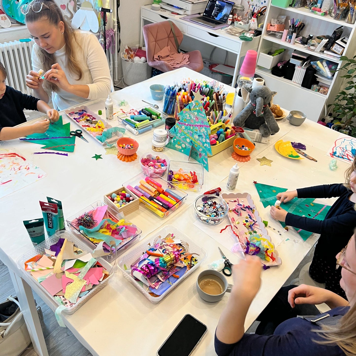 Children engaged in craft activities at a table with various art supplies.