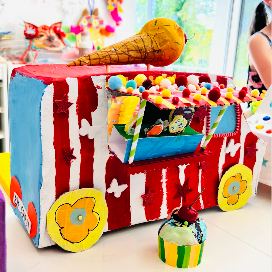 Colorful children's play area with a toy truck and various toys in a bright room.